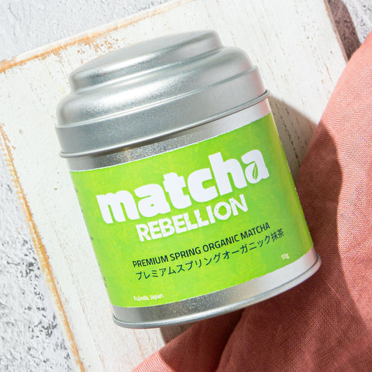 Tea Rebellion matcha product on a light gray surface .